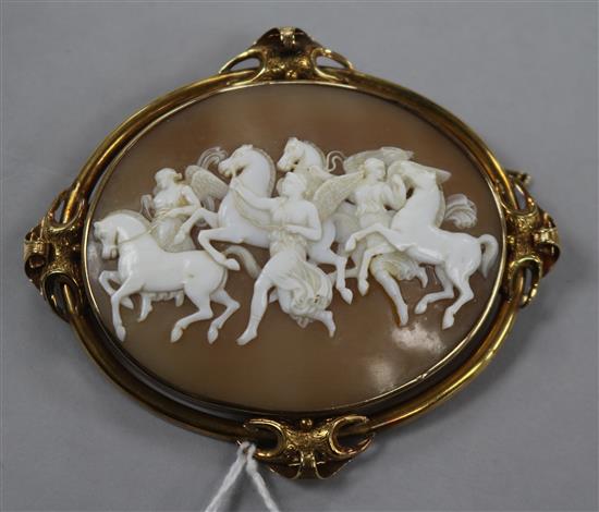 A Victorian gold mounted oval cameo brooch carved with figures and winged horses, 81mm.